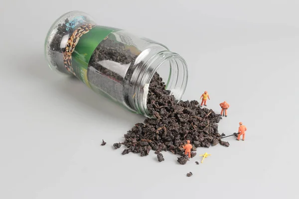 Liści herbaty i miniaturowe domyślić osób pracujących — Zdjęcie stockowe