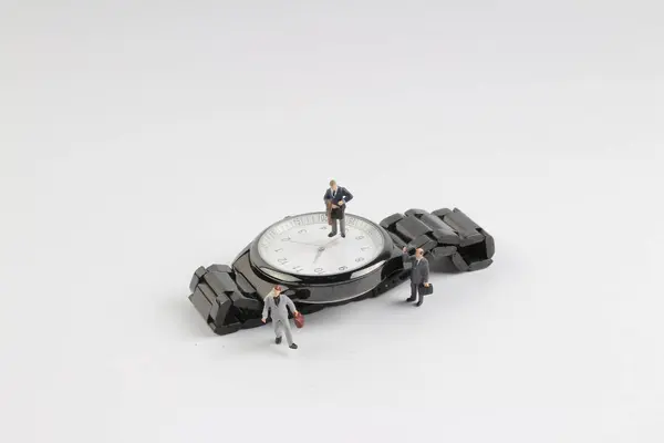 Mini homme d'affaires figure debout sur la montre — Photo