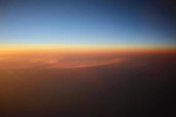 O pôr do sol acima das nuvens no avião — Fotografia de Stock