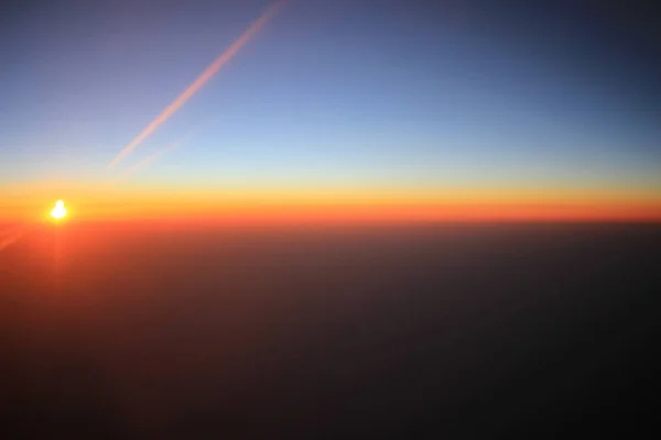 Solnedgången över moln på planet — Stockfoto