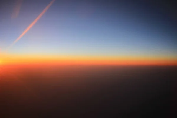 Le coucher du soleil au-dessus des nuages sur l'avion — Photo