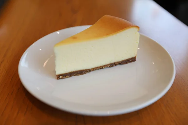 Ahşap arka plan üzerinde izole peynir pasta — Stok fotoğraf