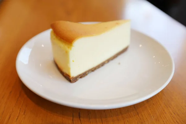 Ahşap arka plan üzerinde izole peynir pasta — Stok fotoğraf