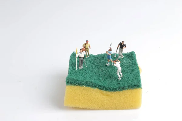 Mini-Figuren spielen Golf auf Schwämmen — Stockfoto