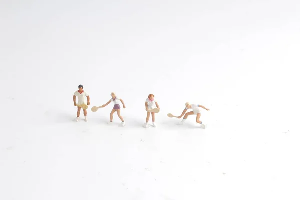 Tiny toys play tennis on white board — Stock Photo, Image