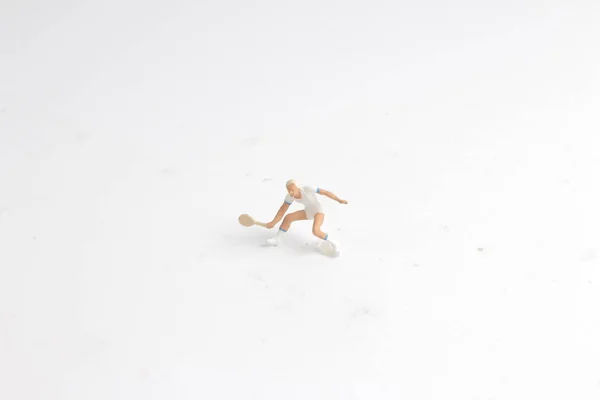 Крихітні іграшки грають в теніс на білій дошці — стокове фото