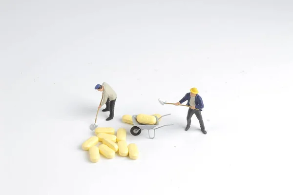 Figura do trabalhador na frente dos comprimidos — Fotografia de Stock