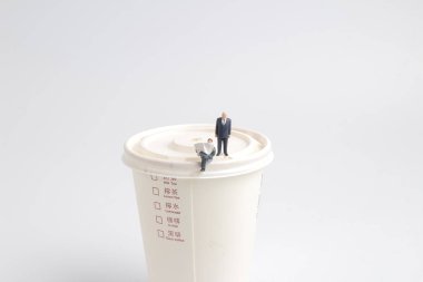 şekil oturup kağıt kupa gazete okuyun