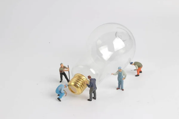 Karakter van de werknemer als elektricien met lamp — Stockfoto