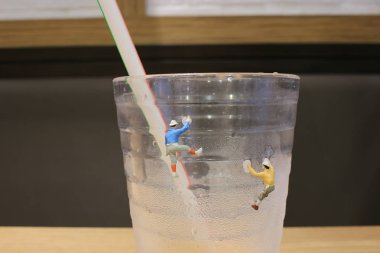 Te içki tırmanma spor yapan mini insanlar izole