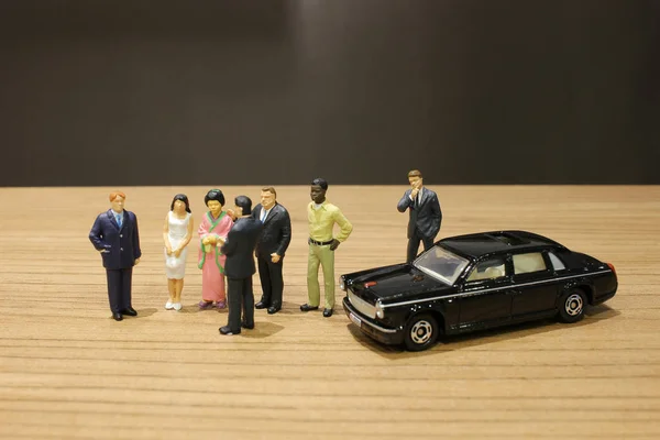 Negócio minúsculo e carro de brinquedo com a reunião — Fotografia de Stock