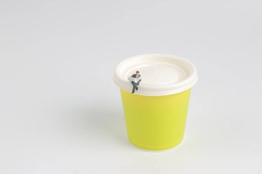  Mini figür oturma ve kağıt bardak üzerinde okuma 