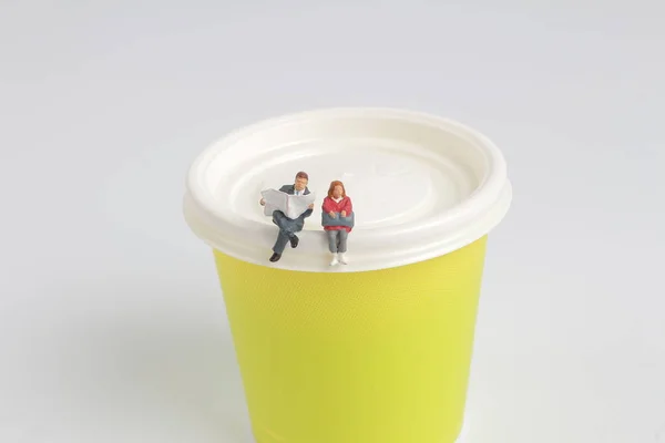 Mini figure sitting and read on paper cup — Stock Photo, Image