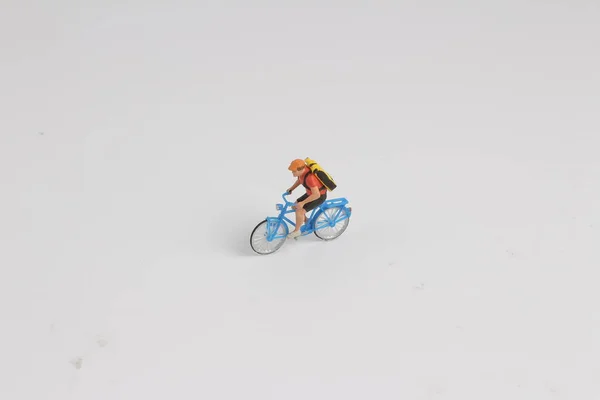 the min figure of man ride bicycle on white