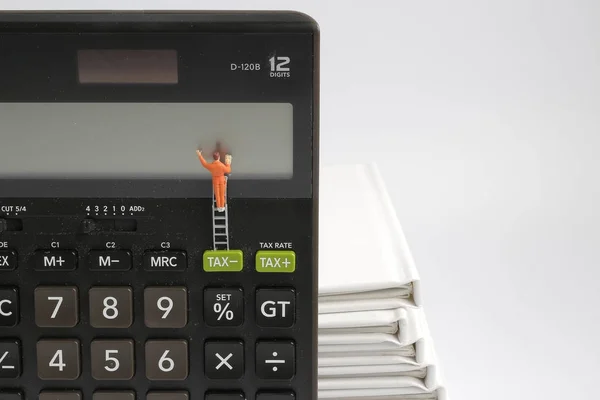 Mini  people figure standing on clearing  calculator — Stock Photo, Image