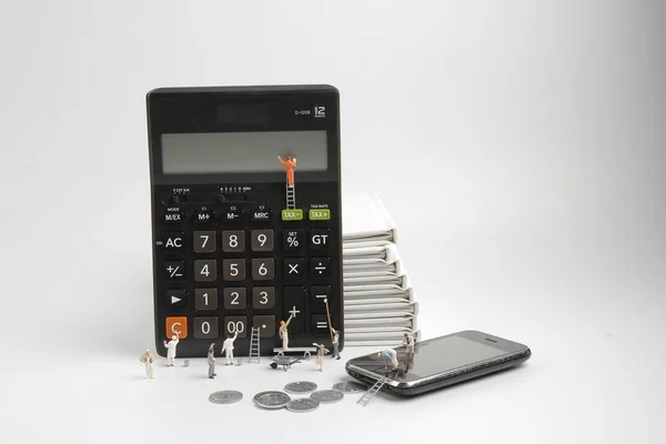 Figura de mini personas de pie en la calculadora de compensación — Foto de Stock