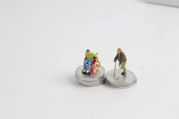 Wheel chair and  crutches stand on the coins — Stock Photo, Image