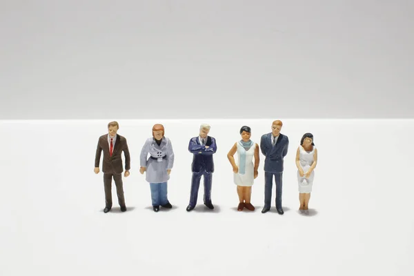 Mini figuras de negócios em terra traseira branca — Fotografia de Stock