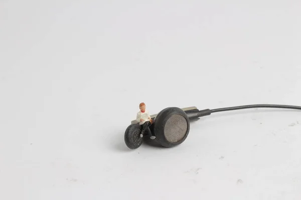 Міні-фігури, що сидять на навушниках — стокове фото