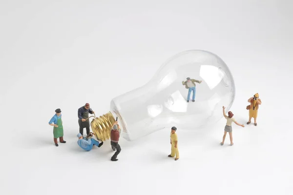 Group of figure working on a  bulb — Stock Photo, Image