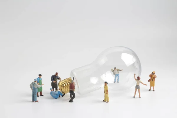 Group of figure working on a  bulb — Stock Photo, Image
