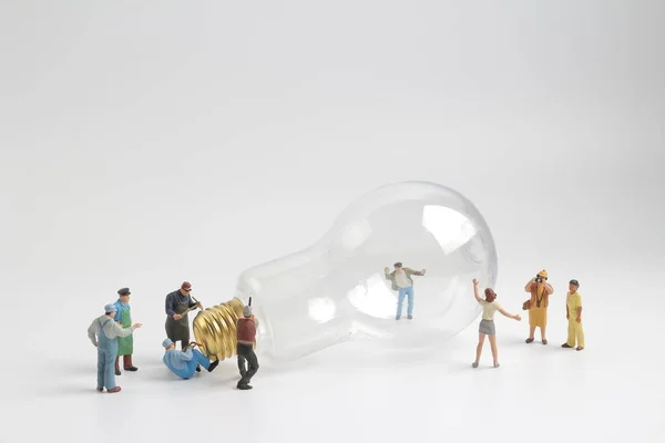 Group of figure working on a  bulb — Stock Photo, Image