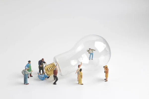 Group of figure working on a  bulb — Stock Photo, Image