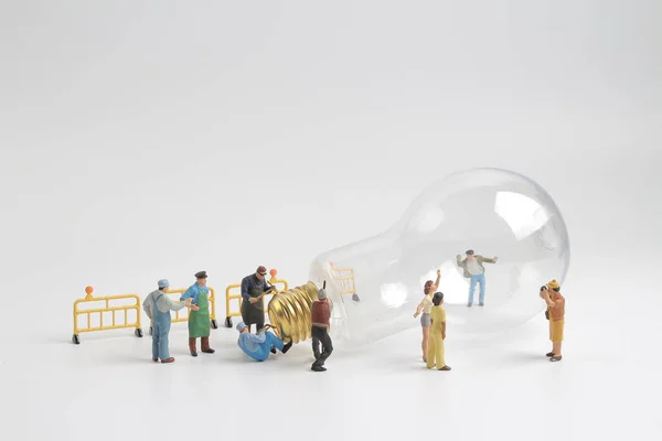 Group of figure working on a  bulb — Stock Photo, Image