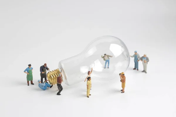 Group of figure working on a  bulb — Stock Photo, Image