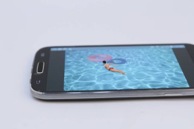küçük rakam havuzunda Ralaxing. Hareket eden telefon 