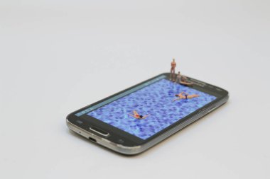 küçük rakam havuzunda Ralaxing. Hareket eden telefon 