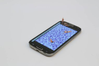 küçük rakam havuzunda Ralaxing. Hareket eden telefon 