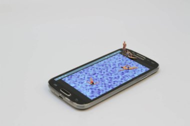 küçük rakam havuzunda Ralaxing. Hareket eden telefon 
