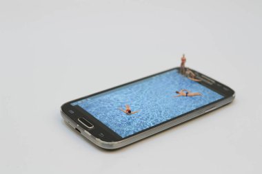 küçük rakam havuzunda Ralaxing. Hareket eden telefon 