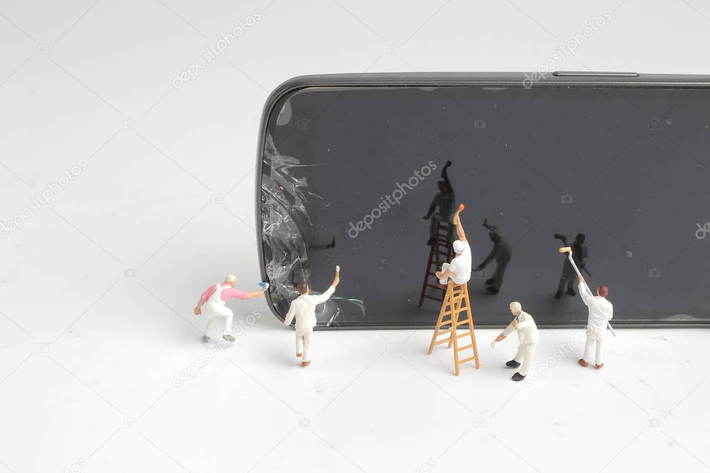 a mini people worker cleaning smart phone screen