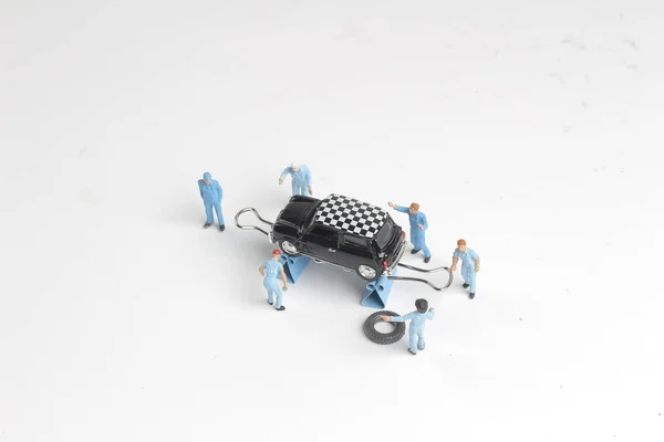 Mini figure mechanics working on a car — Stock Photo, Image