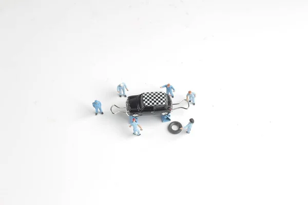 Mini figure mechanics working on a car — Stock Photo, Image