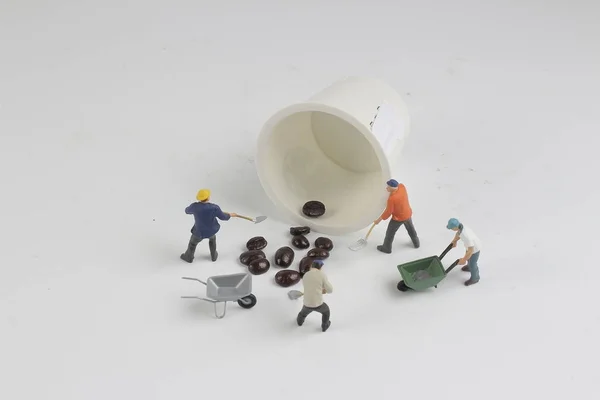 Um mini-pessoas trabalhando em grãos de café torrados — Fotografia de Stock