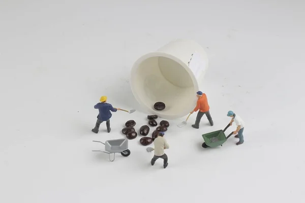 A mini people working on roasted coffee beans — Stock Photo, Image