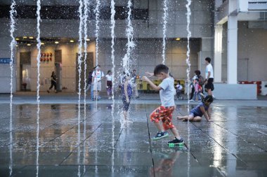 Çeşme binası önünde ile oynayan mutlu çocuk