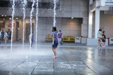 Çeşme binası önünde ile oynayan mutlu çocuk
