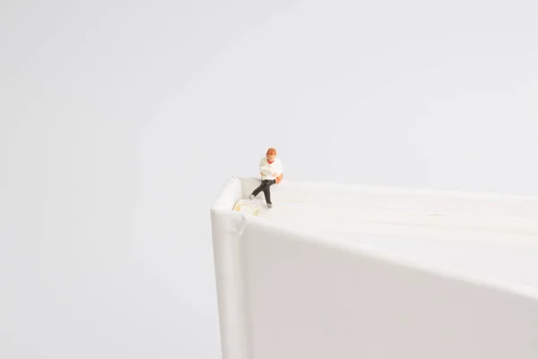 Il divertimento della mini figura che legge sul libro — Foto Stock