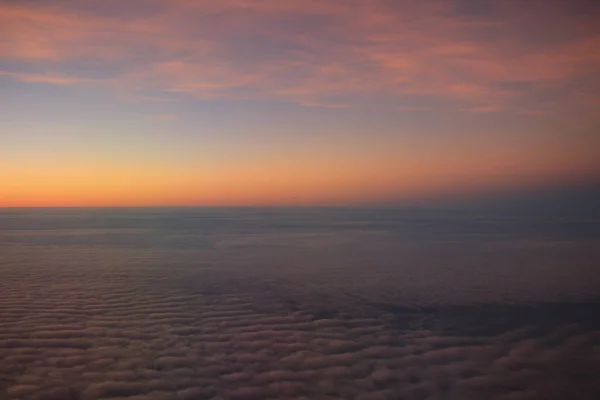 Der Blick auf den Sonnenuntergang aus dem Flugzeugfenster — Stockfoto