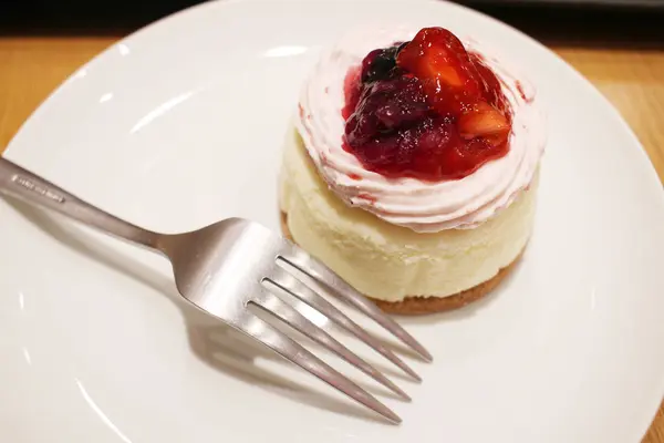 Ein Käsekuchen mit Waldbeeren auf weißem Teller — Stockfoto