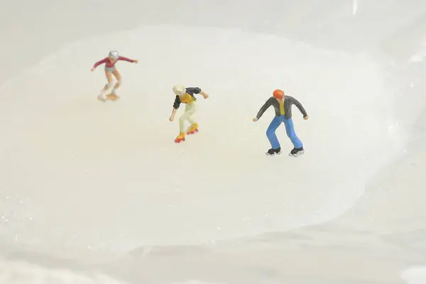 Zabawa z maleńką zabawkę łyżwiarzy na lodzie — Zdjęcie stockowe