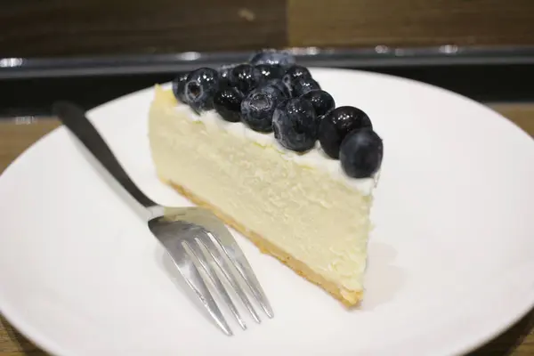 Gâteau au fromage aux baies bleues sur fond bois — Photo