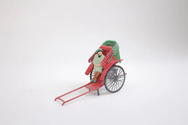 Uma estátua e vermelho vintage oriental rickshaw táxi — Fotografia de Stock