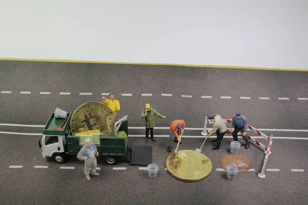 Sebuah tim pekerja mini mengangkat truk bitcoin . — Stok Foto