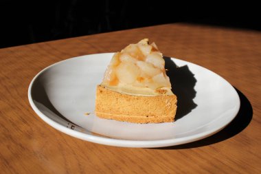 Ahşap masa üzerinde şeftali pasta dilimi