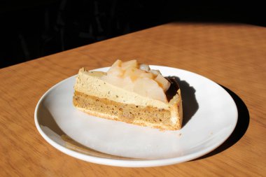 Ahşap masa üzerinde şeftali pasta dilimi